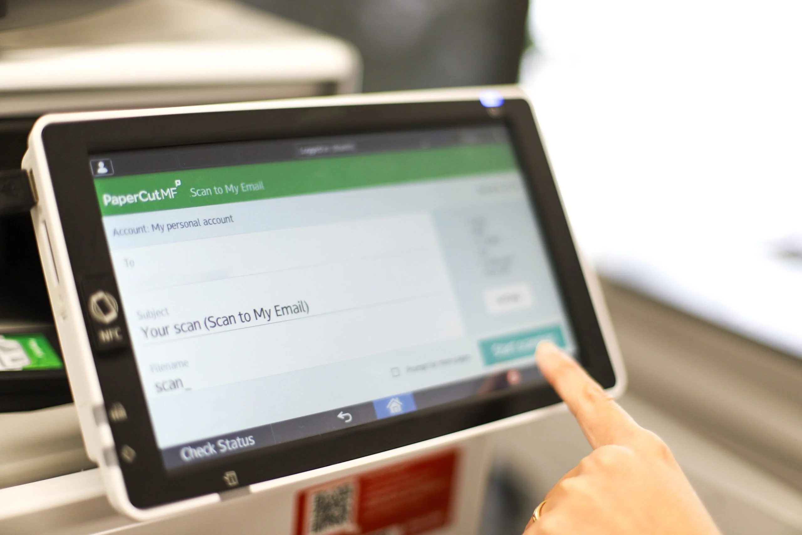 A person using PaperCut on an MFD's touch screen